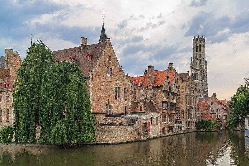 Canal junction and medieval brick building at Huidenvettersplein in Bruges